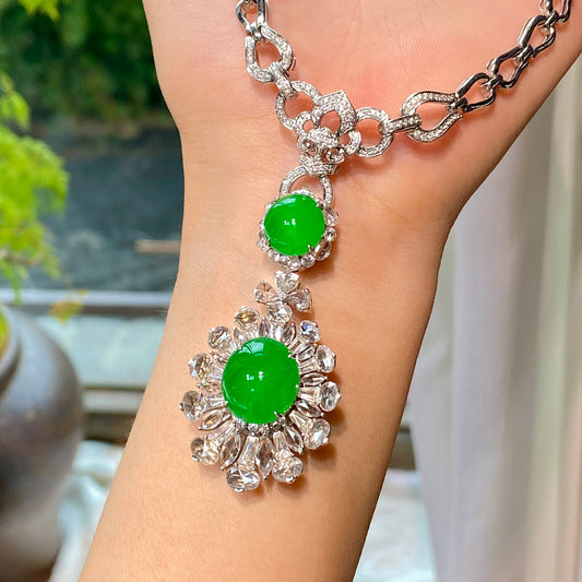 Silver-tone necklace with two green cabochon pendants and diamond-like halo stones