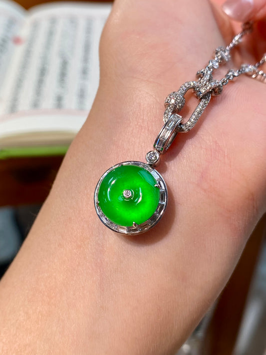 Green jadeite round donut pendant in silver bezel on wrist, chain links