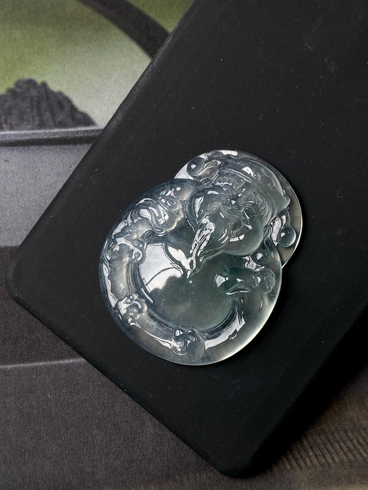 Icy white jadeite money god pendant with oval carved relief, glossy dark-tone view