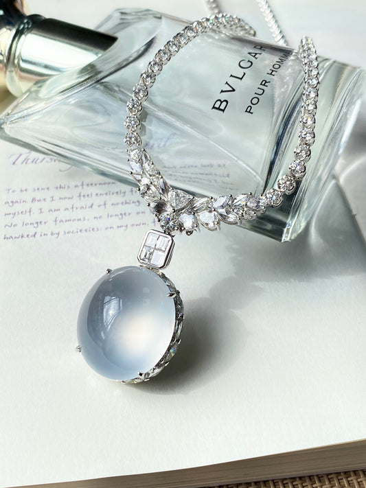 Silver-tone rhinestone necklace featuring oval light-blue cabochon pendant