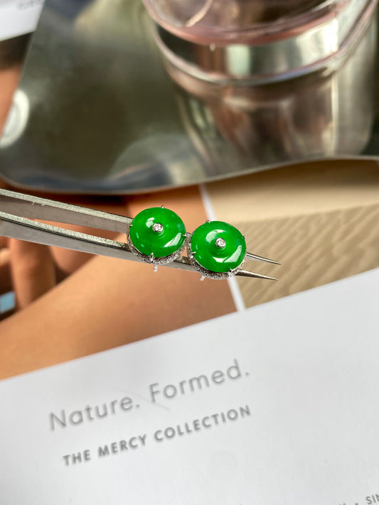 Green jadeite donut stud earrings, close view of glossy round discs and silver posts.