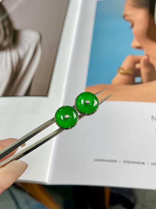 Pair of green jadeite donut stud earrings, glossy round centers with silver posts.