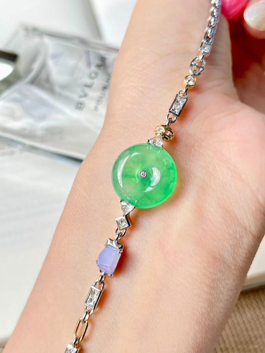 Jadeite donut bracelet on wrist with green round charm and purple accent stone