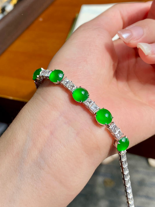 Green jadeite cabochon bracelet close-up on hand, round green stones and silver bar settings