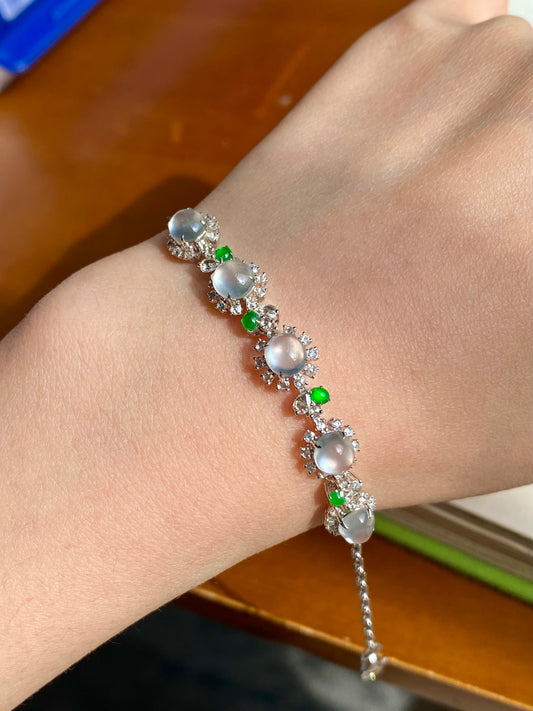 Jadeite cabochon bracelet on wrist with oval white stones, green beads, and silver links