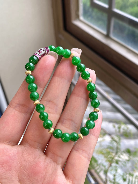 Green jadeite beaded bracelet with red centerpiece and gold bead accents