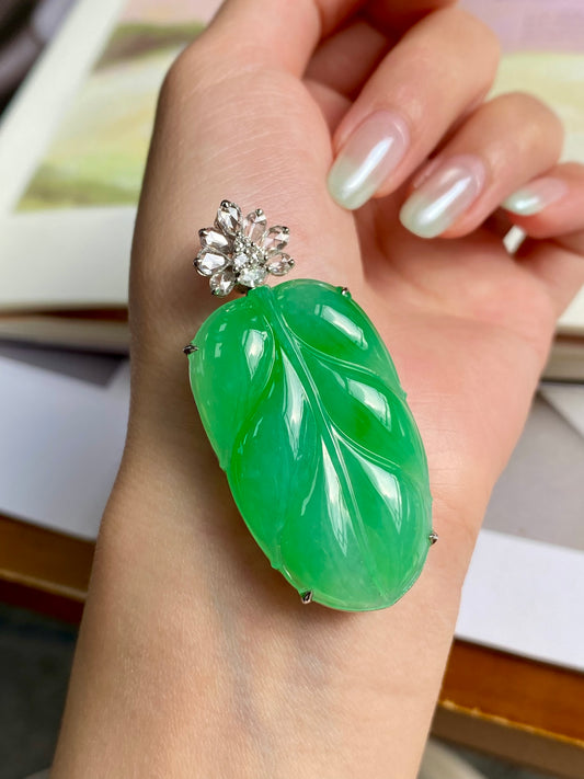 Green leaf jadeite pendant on open hand, silver-tone setting with crystal flower top