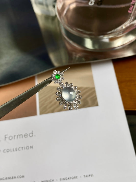 Jadeite cabochon pendant with round pale center, green accent, and crystal-like halo