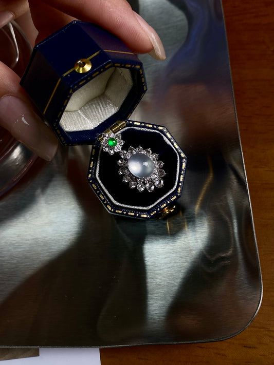 Jadeite cabochon pendant in octagonal black setting with green accent and floral halo