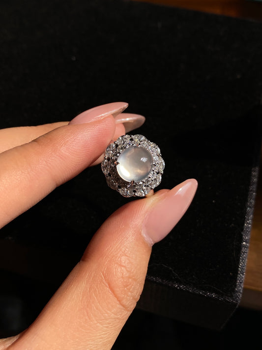 Icy white jadeite cabochon ring with round pavé halo setting