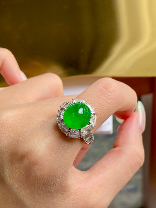 Hand close-up of green jade cabochon ring with halo of clear gems