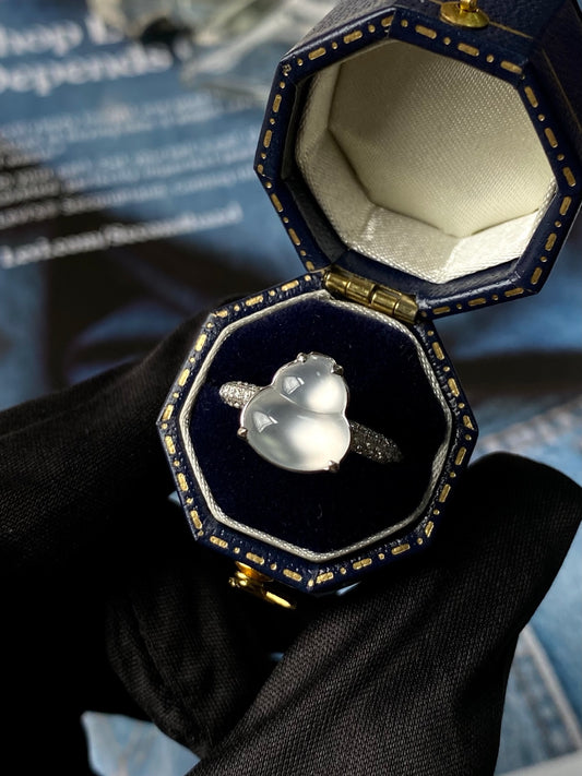 Silver-tone ring with heart-shaped light cabochon in a small jewelry box