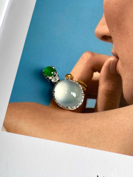 Jadeite cabochon pendant worn on chain with green round stone and white oval cabochon