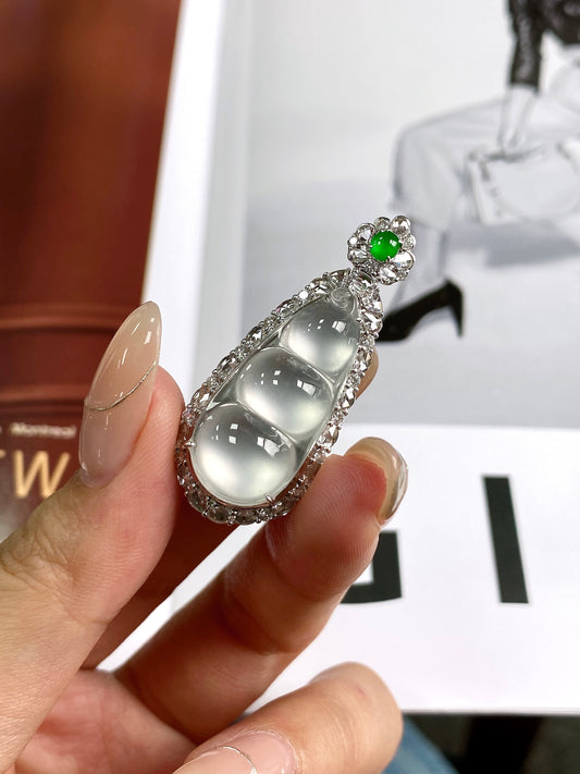 Rhinestone bean pendant with green round top and elongated silver frame, side view