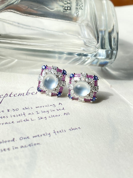 Light blue oval cabochon stud earrings with purple crystal accents in square settings