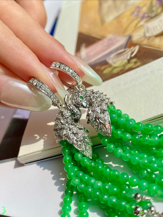Rhinestone peacock motif earrings with bright green bead tassel drops
