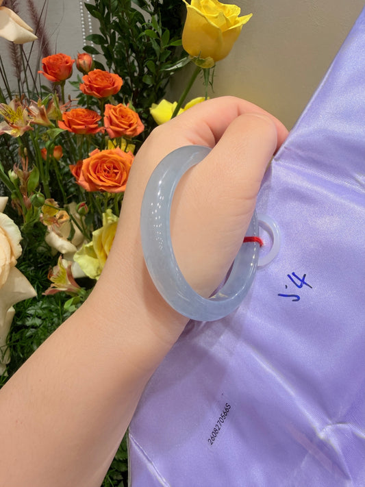 Light blue translucent bangle bracelet worn on wrist, smooth glossy texture.