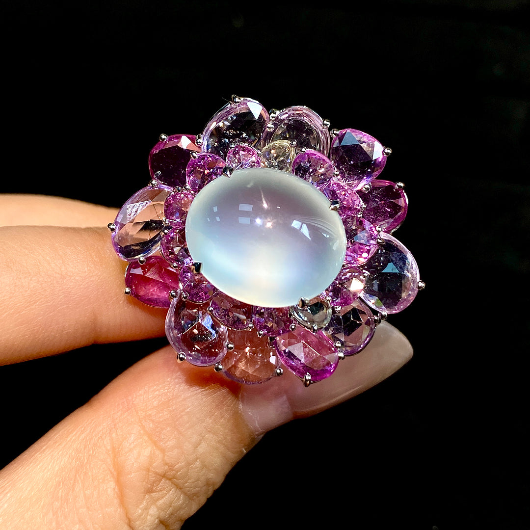 Floral gemstone ring with oval opalescent cabochon and purple crystal halo, sterling band