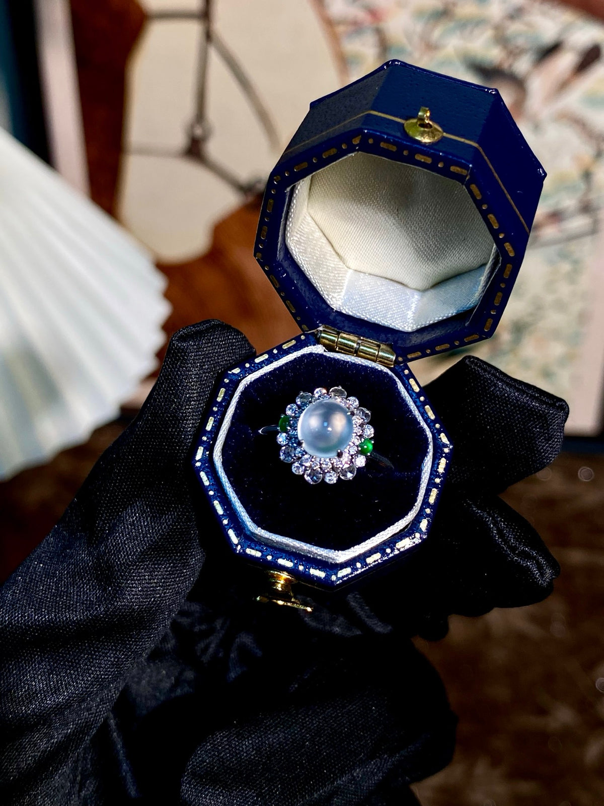 Jadeite cabochon ring with round blue center stone and halo of clear crystals