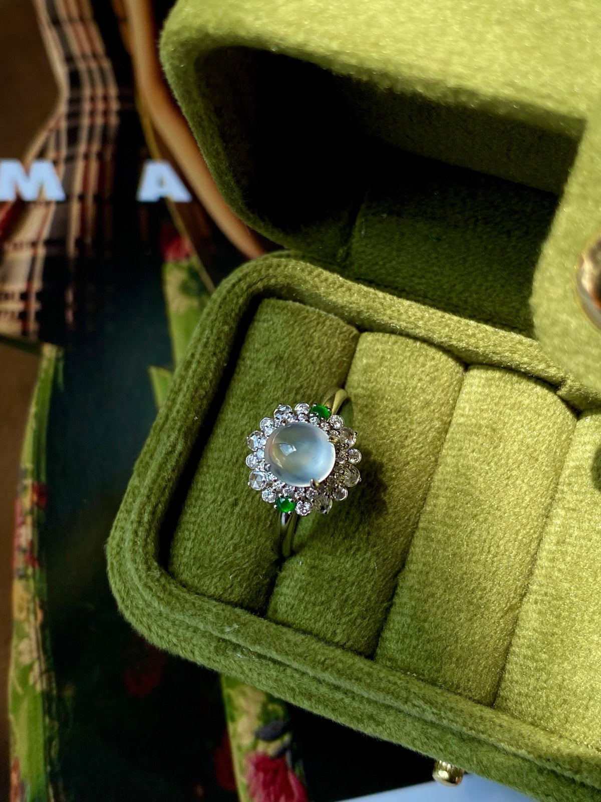 Jadeite cabochon ring with round blue cabochon, crystal halo, and silver band