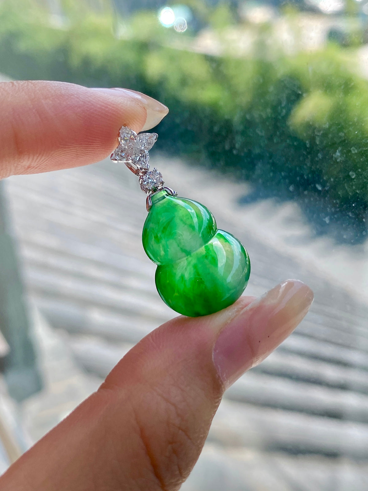 Green jadeite gourd pendant with silver prong cap and faceted diamond-like stones