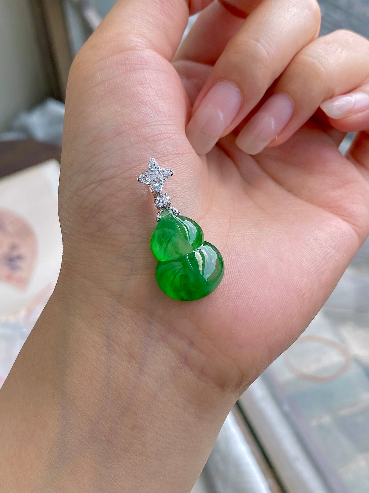 Green jadeite gourd pendant with silver setting and small diamond-like stones
