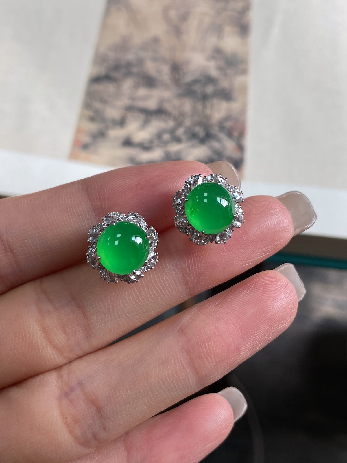 Pair of green jadeite cabochon stud earrings with round halo bezel, silver-tone