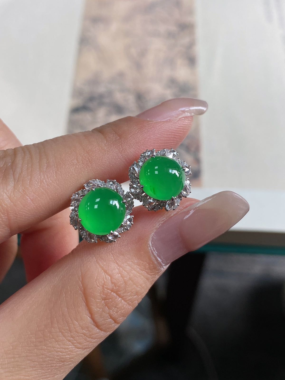 Green jadeite cabochon stud earrings with ornate round halo border, silver-tone