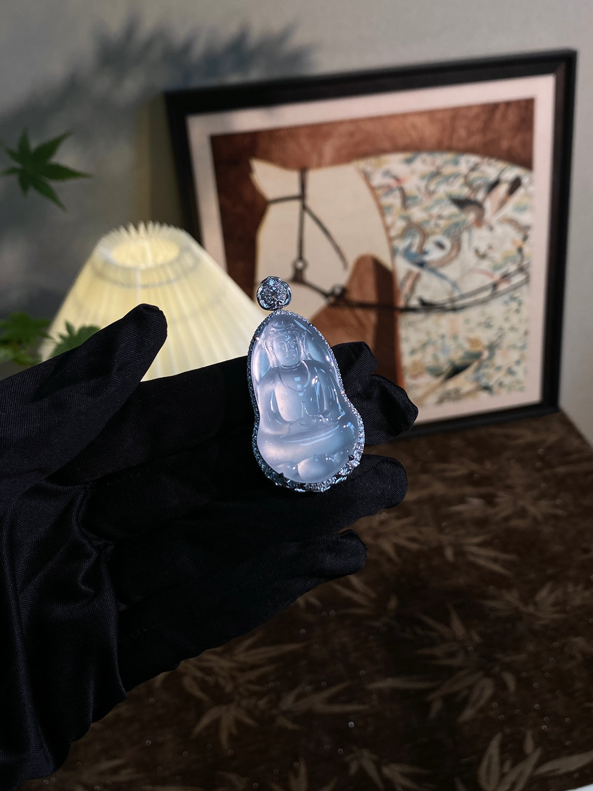 Jadeite Guanyin pendant with icy pale blue carved figure and silver-tone halo around setting