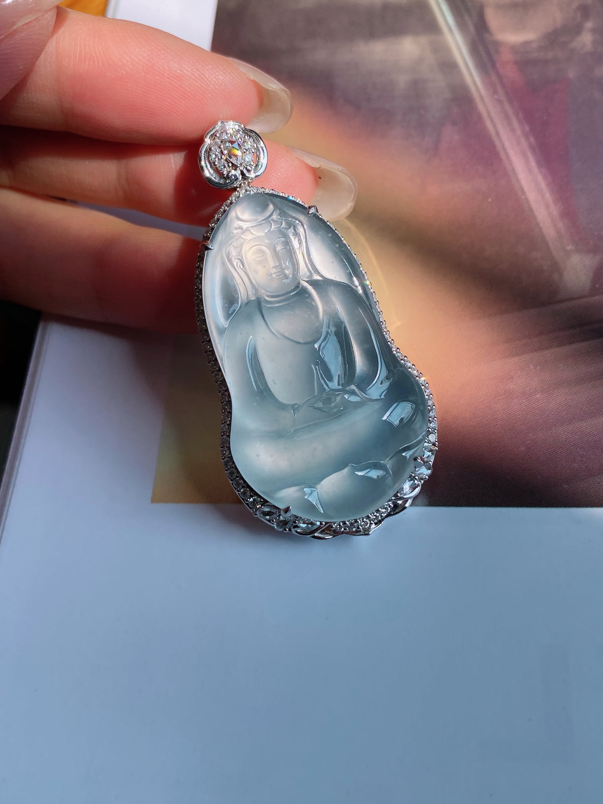 Jadeite Guanyin pendant teardrop with light blue carved Guanyin, silver setting with sparkle rim