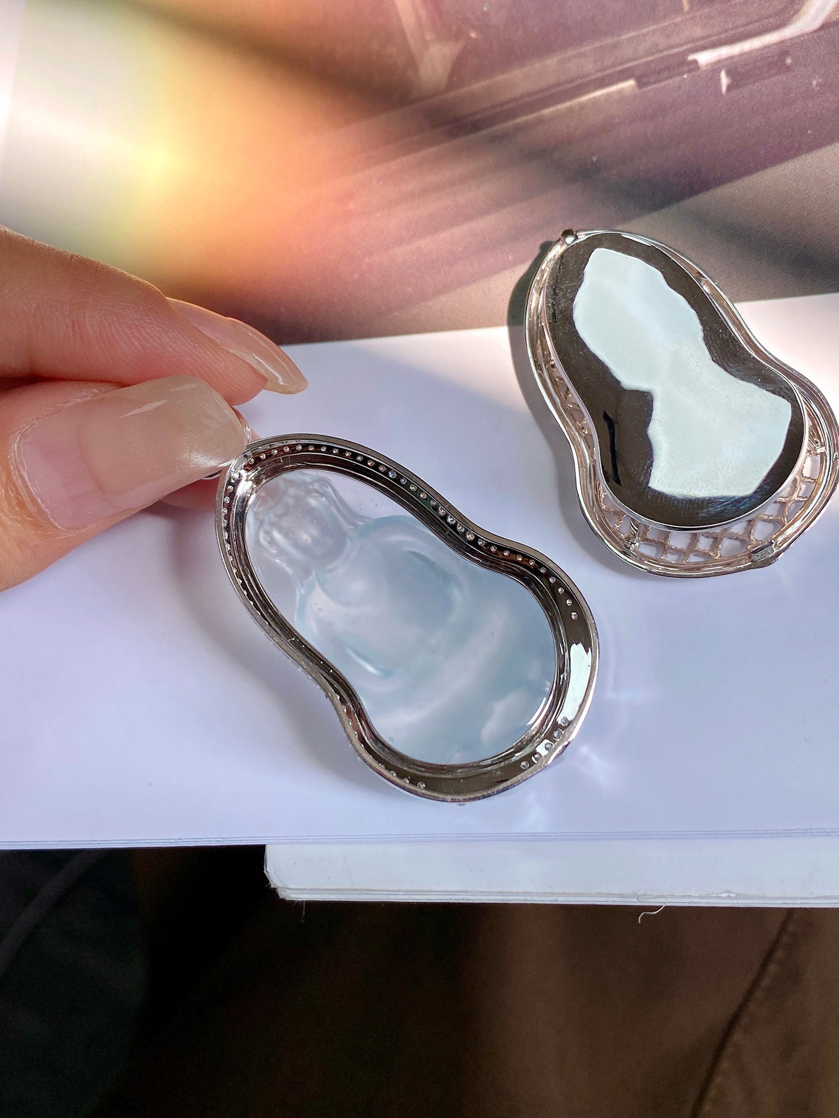 Jadeite Guanyin pendant with icy light blue carved figure in silver-tone bezel