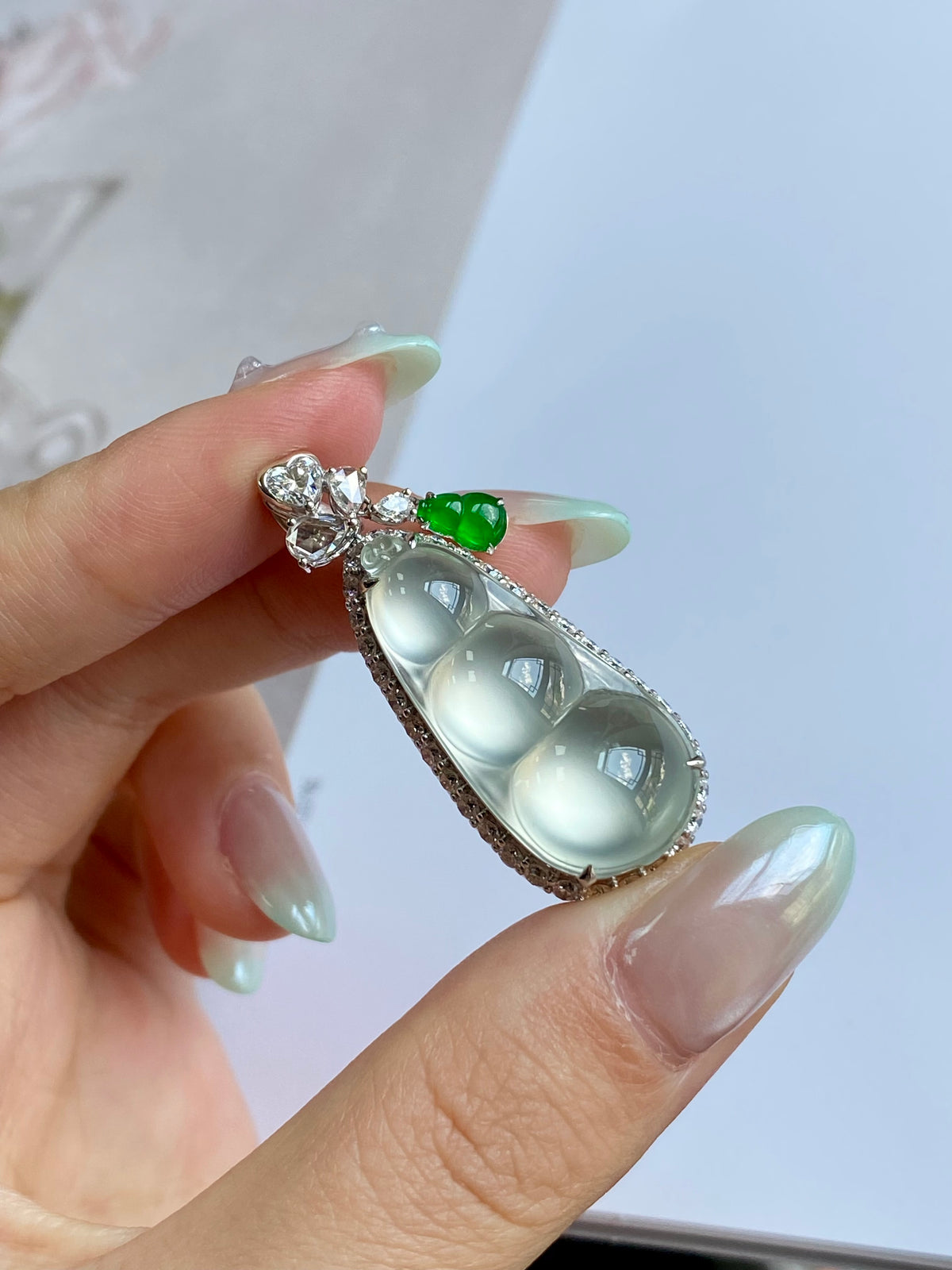Silver-tone filigree pea pod pendant with milky jade cabochon and small green bead
