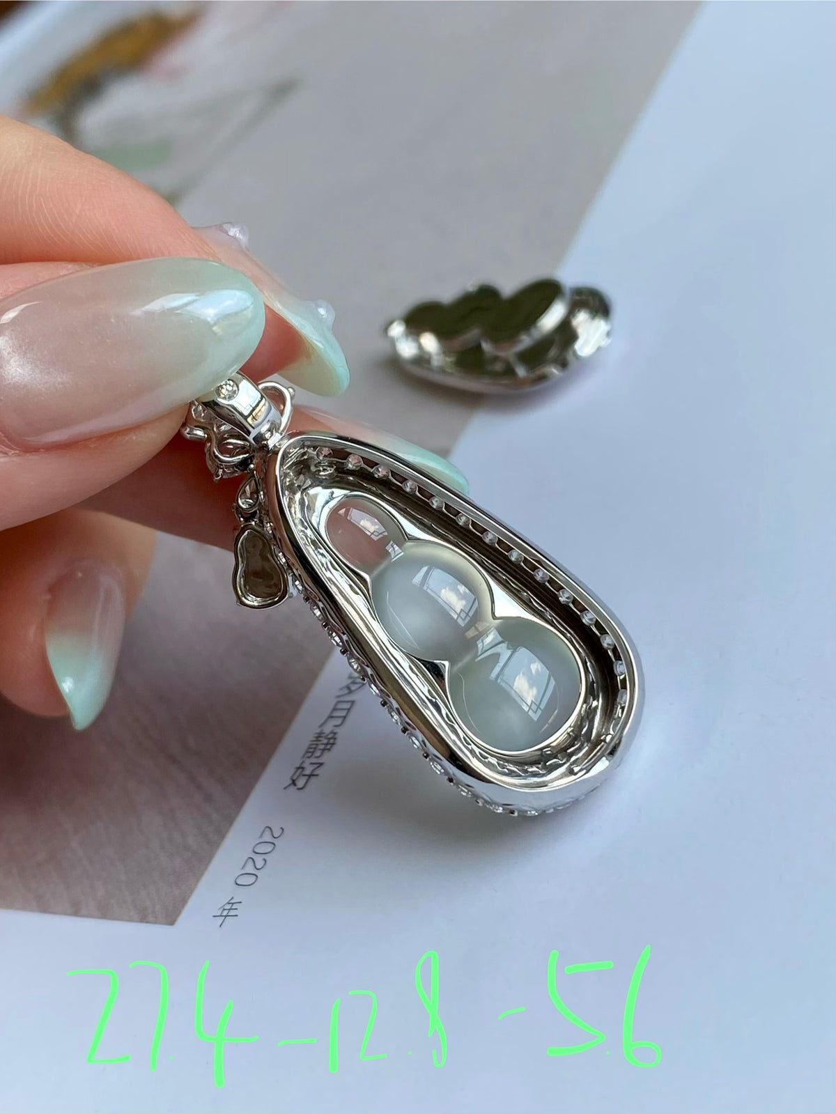 Silver-tone pea pod pendant with milky jade cabochon and small green stone