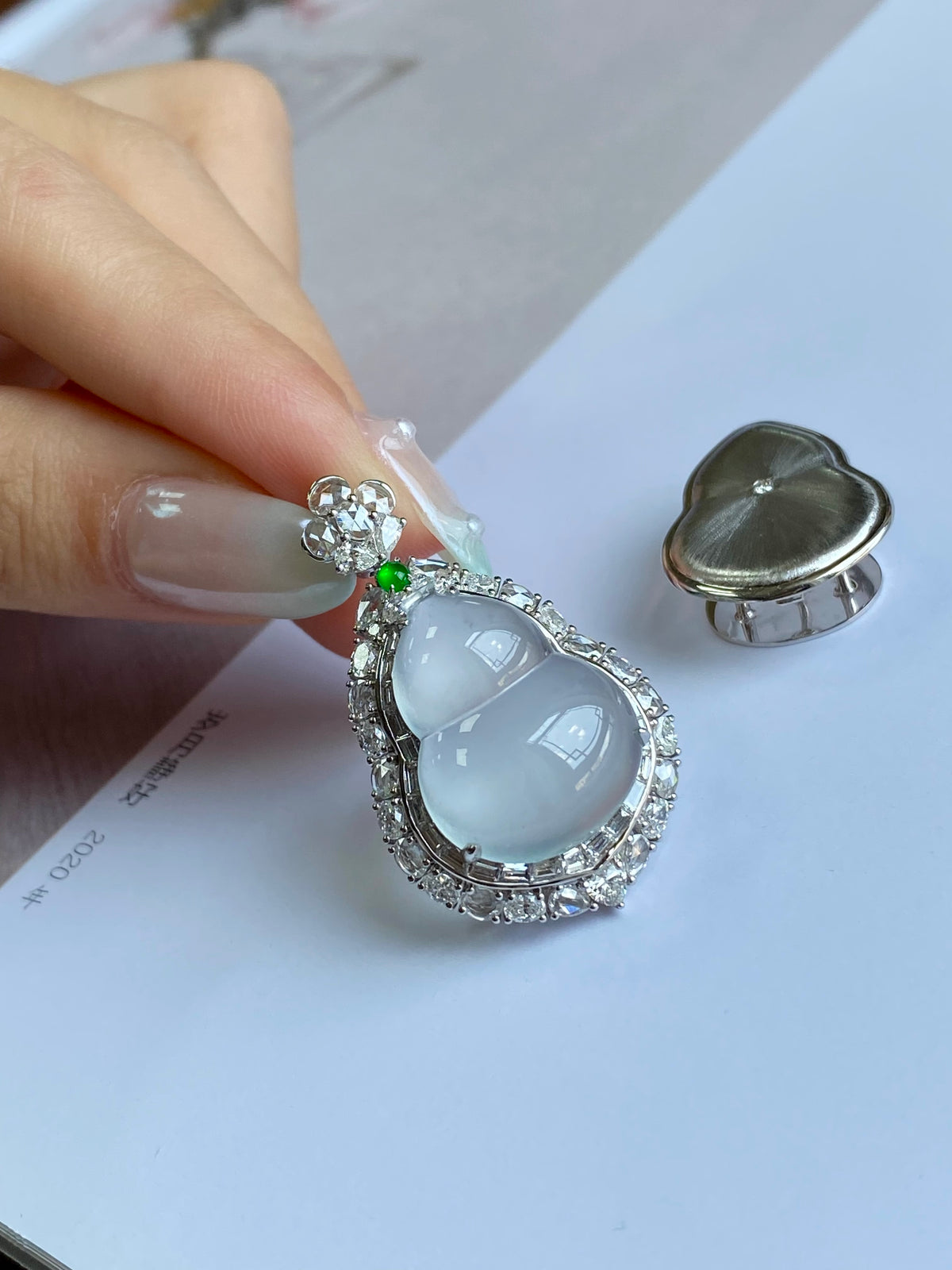 Light blue teardrop jadeite pendant with diamond-like halo and small green accent