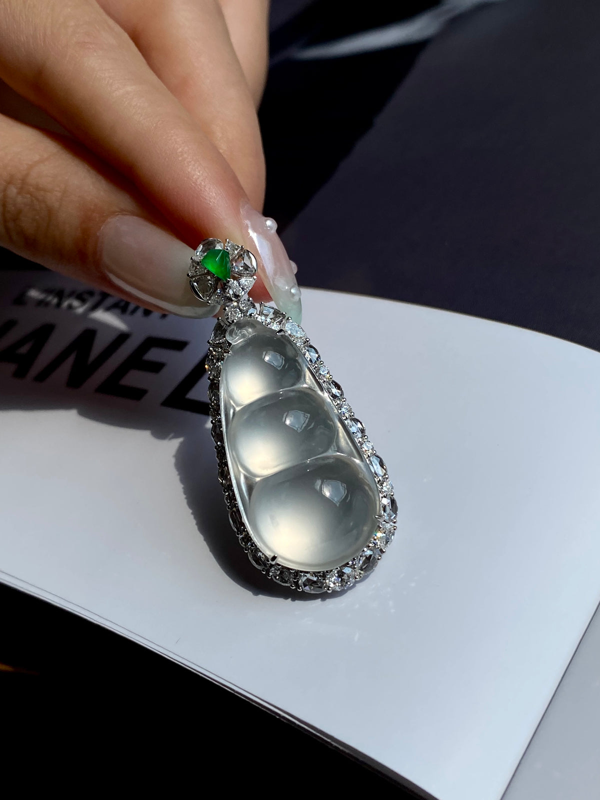 Jadeite pea pod pendant with green top stone and three-oval icy drops in silver frame