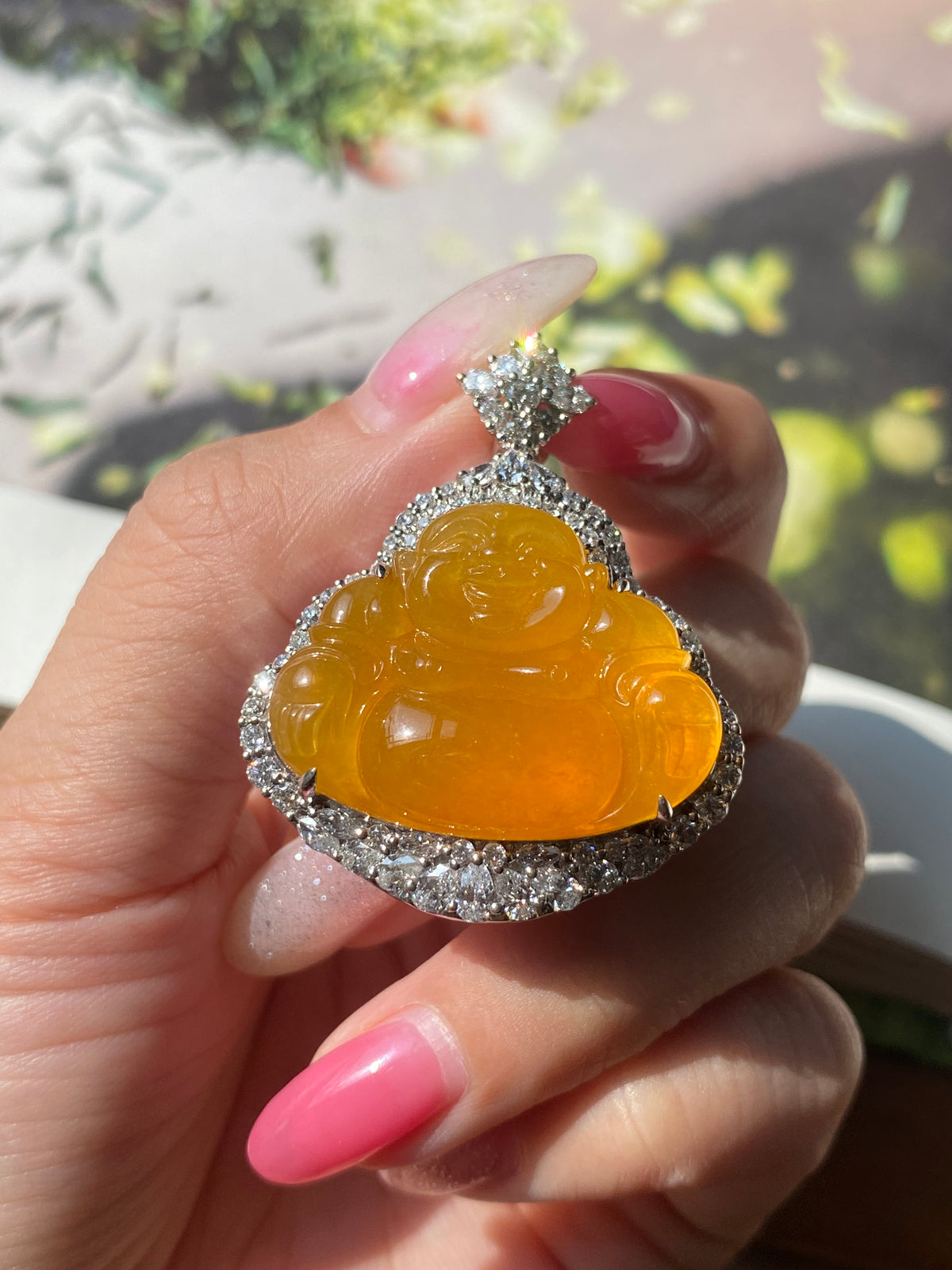 Orange-yellow Laughing Buddha jadeite pendant in silver halo, rhinestone-look
