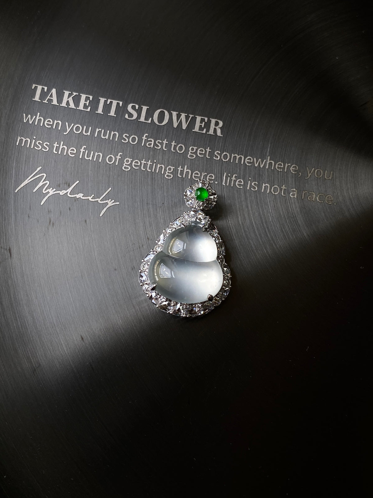 Silver-tone teardrop jade pendant with green top stone and sparkling halo edge