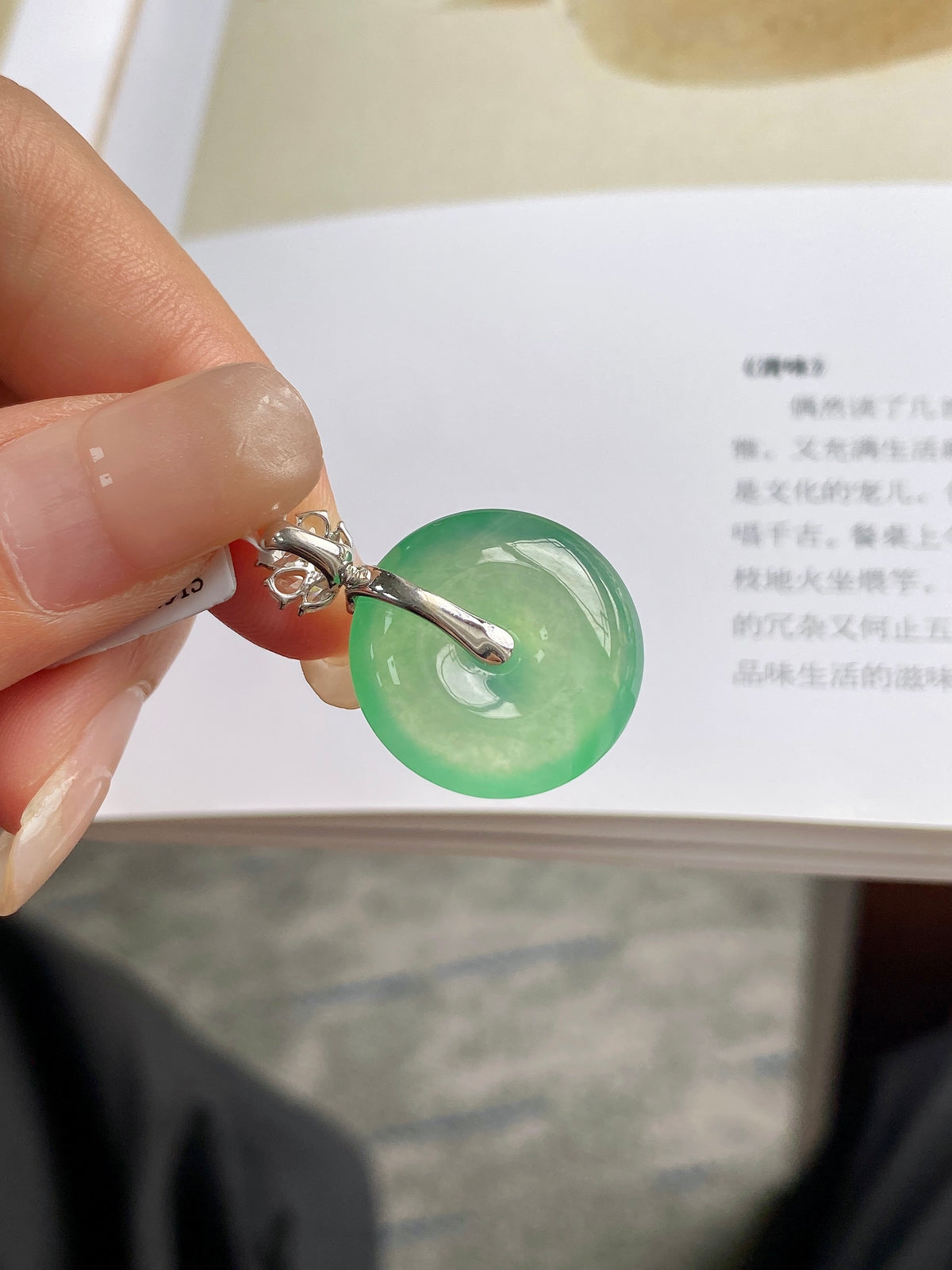 Light green jadeite donut pendant with silver loop and small clear gemstone accents