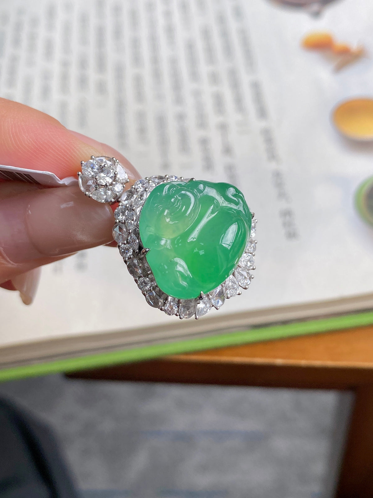 Green jadeite Buddha pendant close-up with diamond-like halo and sculpted face