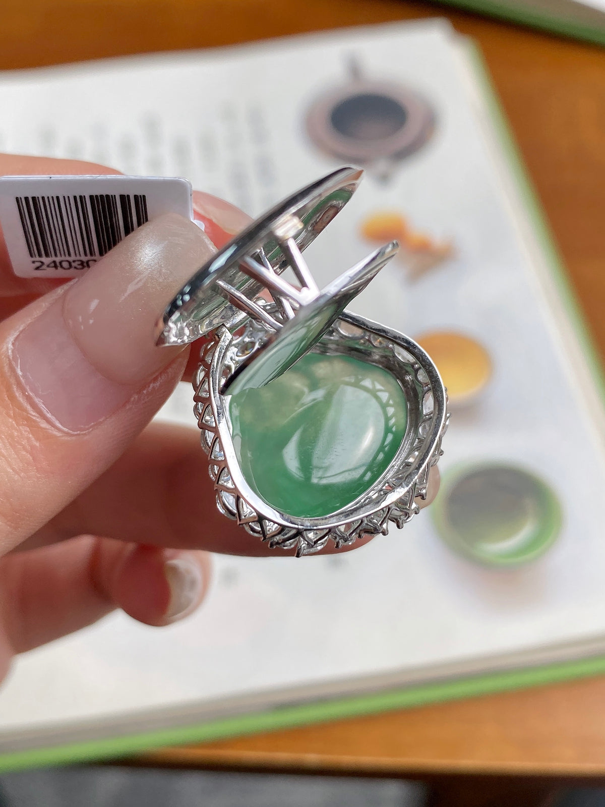 Green jadeite Buddha pendant with ornate silver setting and diamond-like halo