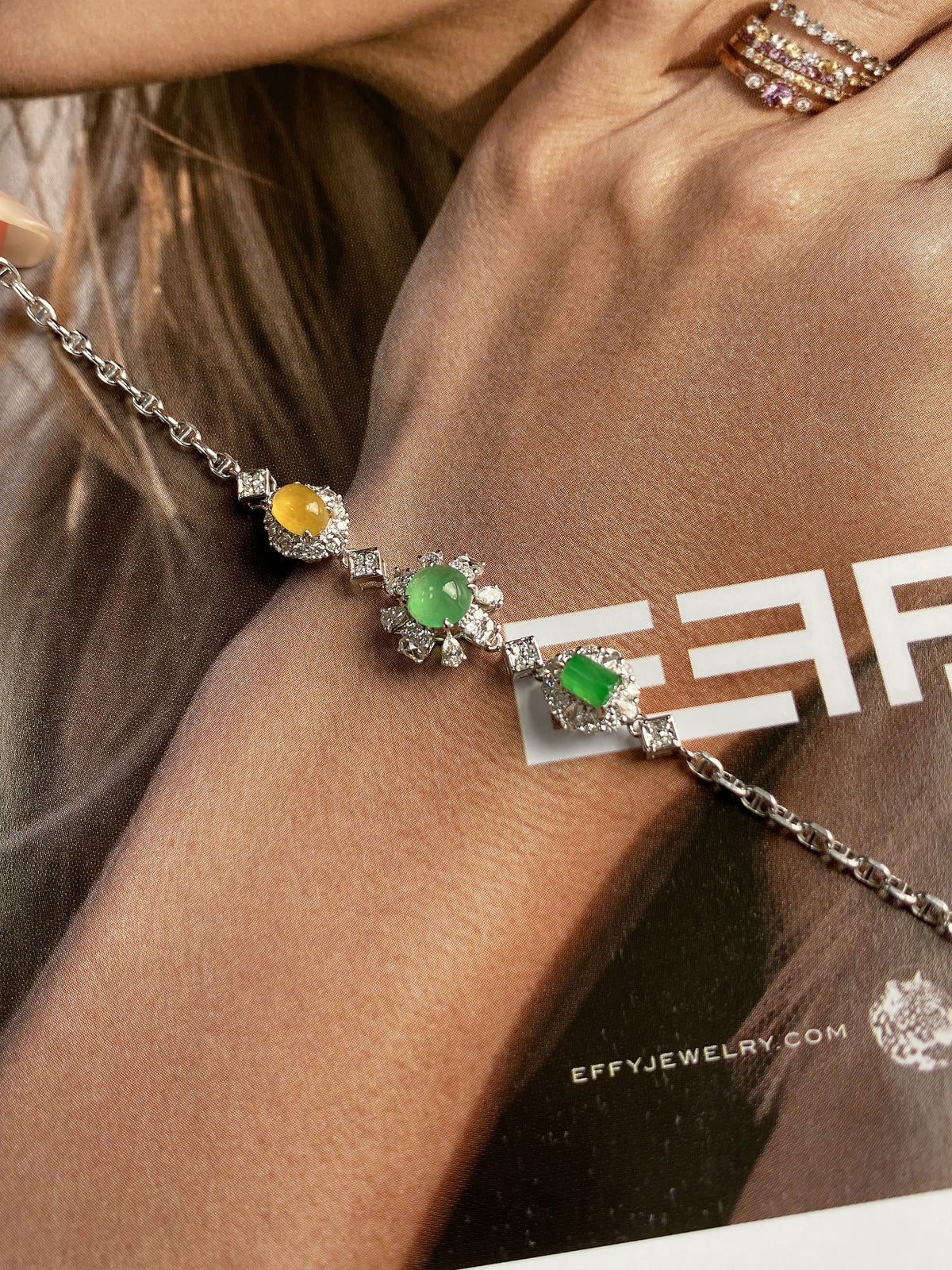 Silver chain bracelet featuring multiple green and yellow cabochon jadeite floral charms