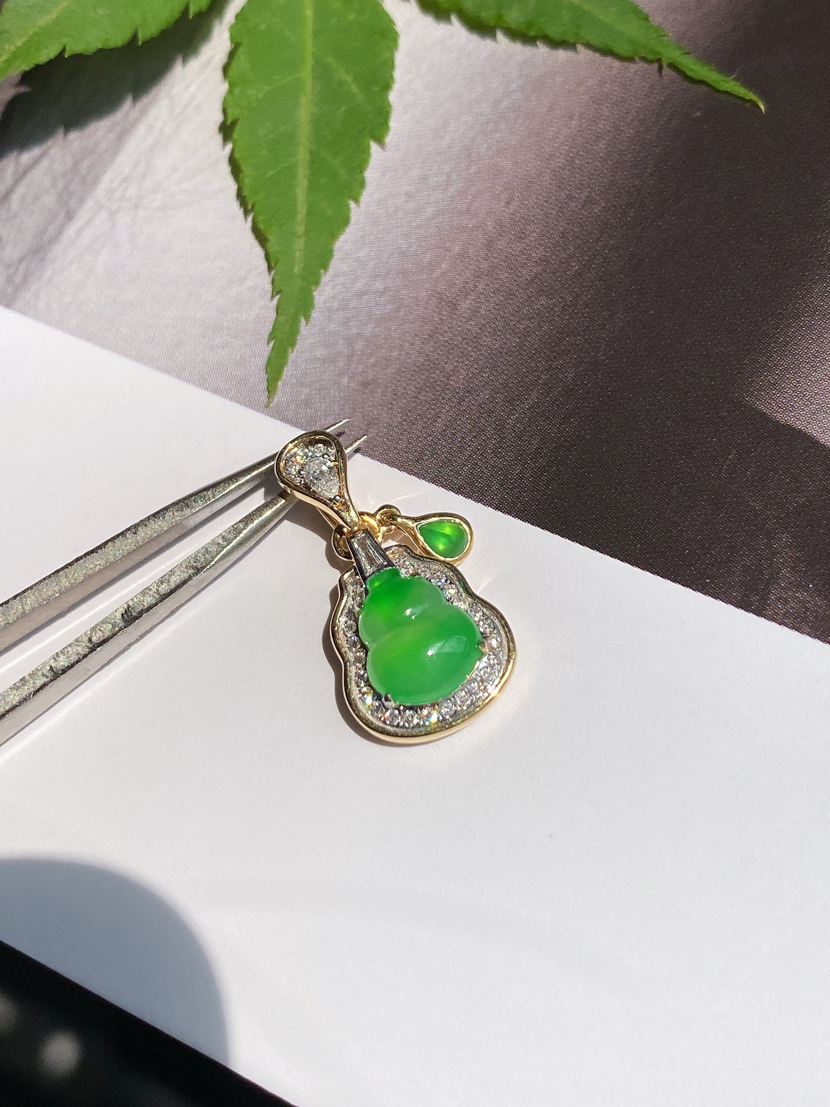 Gold-tone jadeite gourd pendant with vivid green teardrop jade and scalloped crystal rim