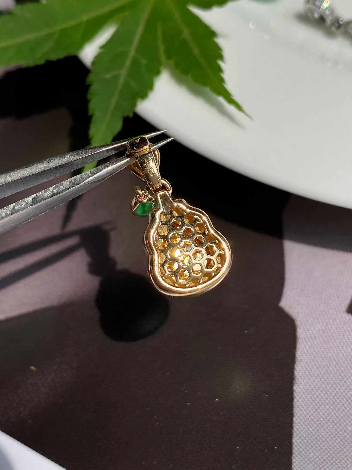 Gold-tone jadeite gourd pendant with honeycomb-pattern back and green enamel accent