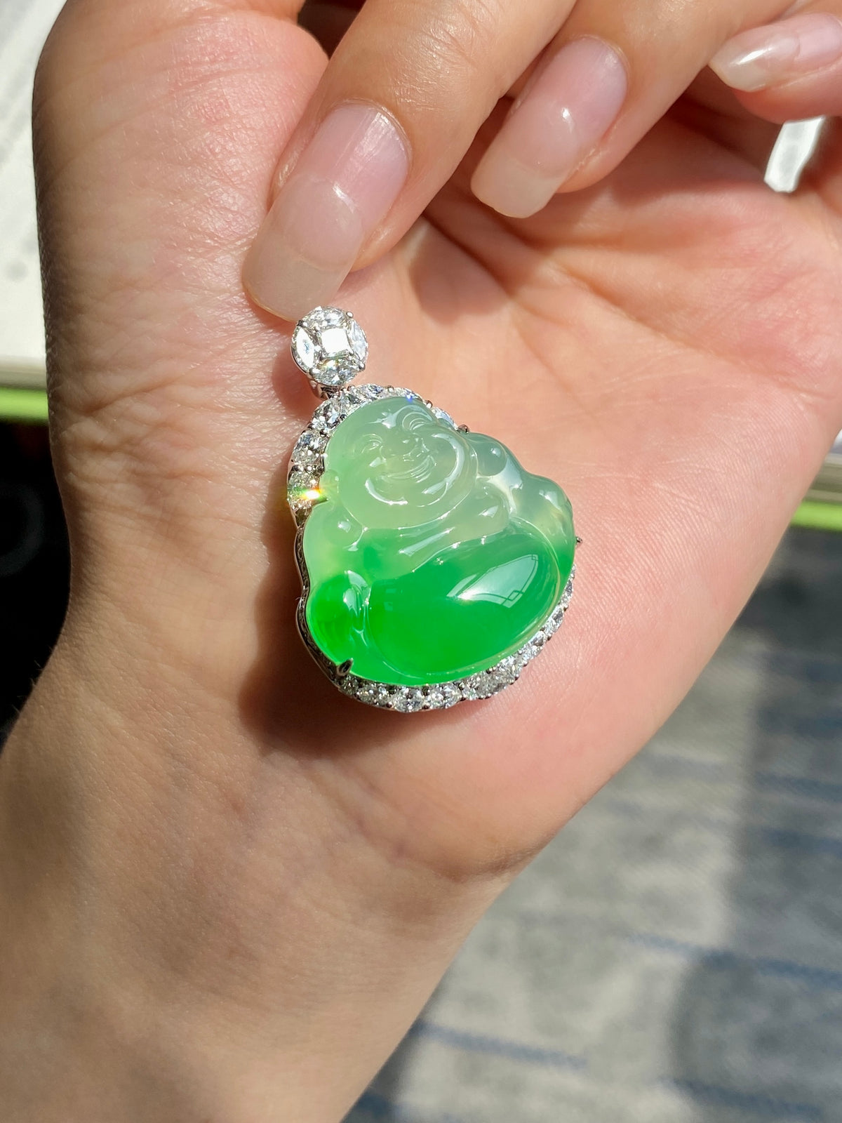 Green oval Buddha jadeite pendant with diamond-look halo in silver setting