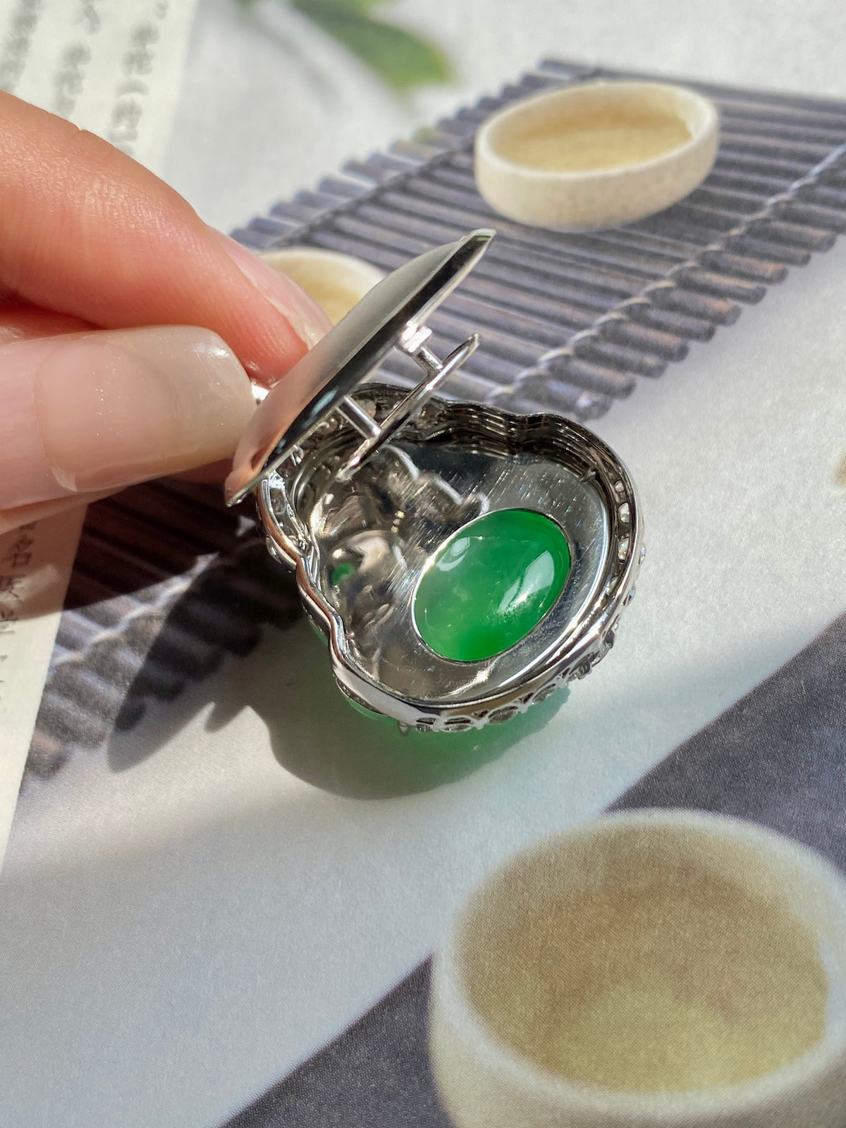 Green jadeite Buddha pendant with silver bezel and pin setting