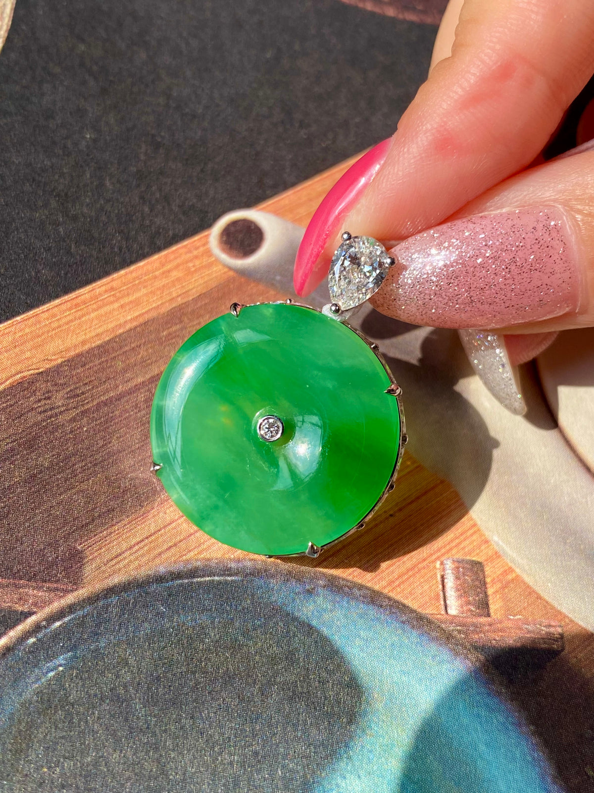 Green jadeite donut pendant with open center, silver prongs, and top round crystal