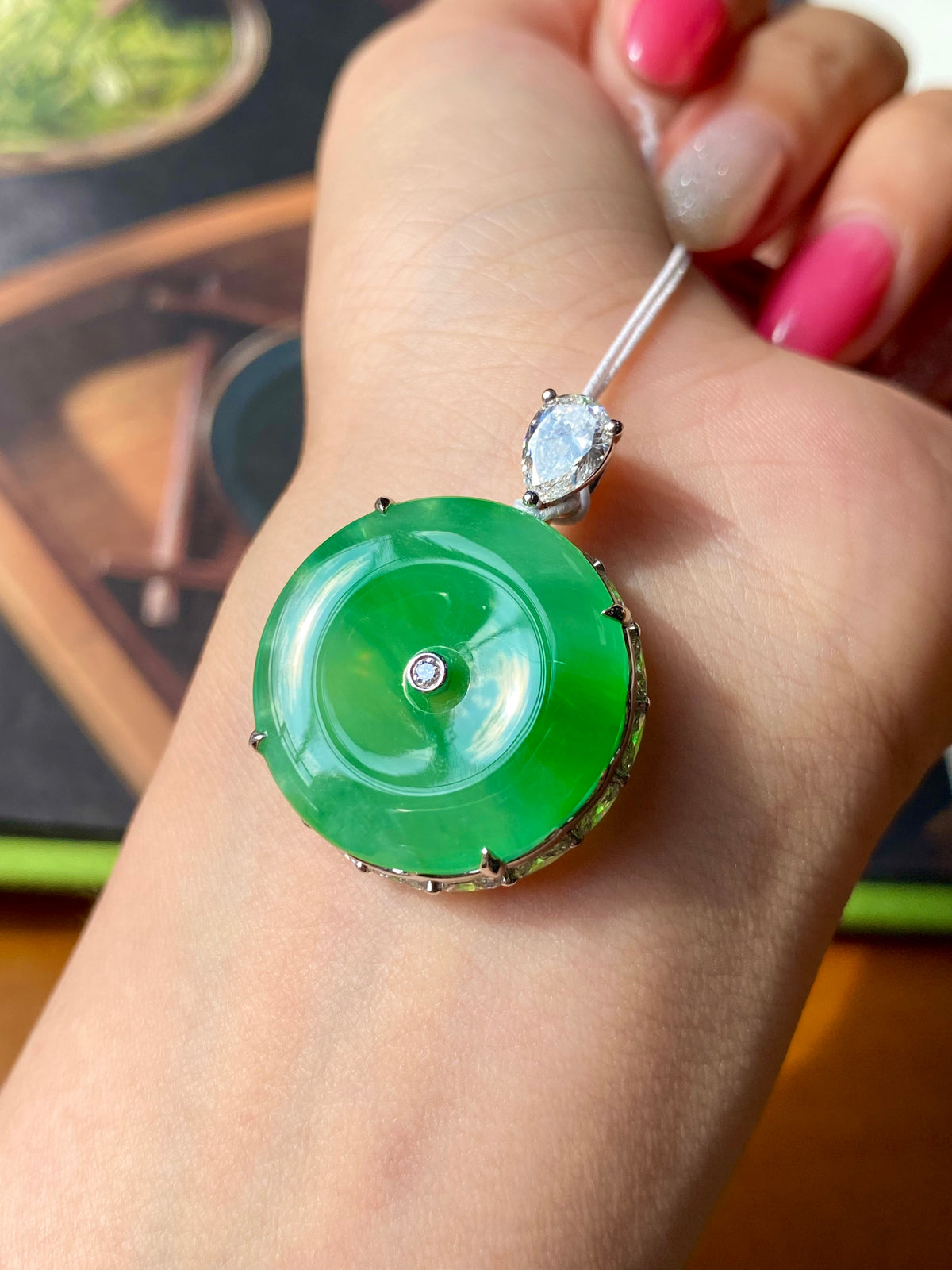 Green jadeite donut pendant with round white stone bezel and silver loop bail