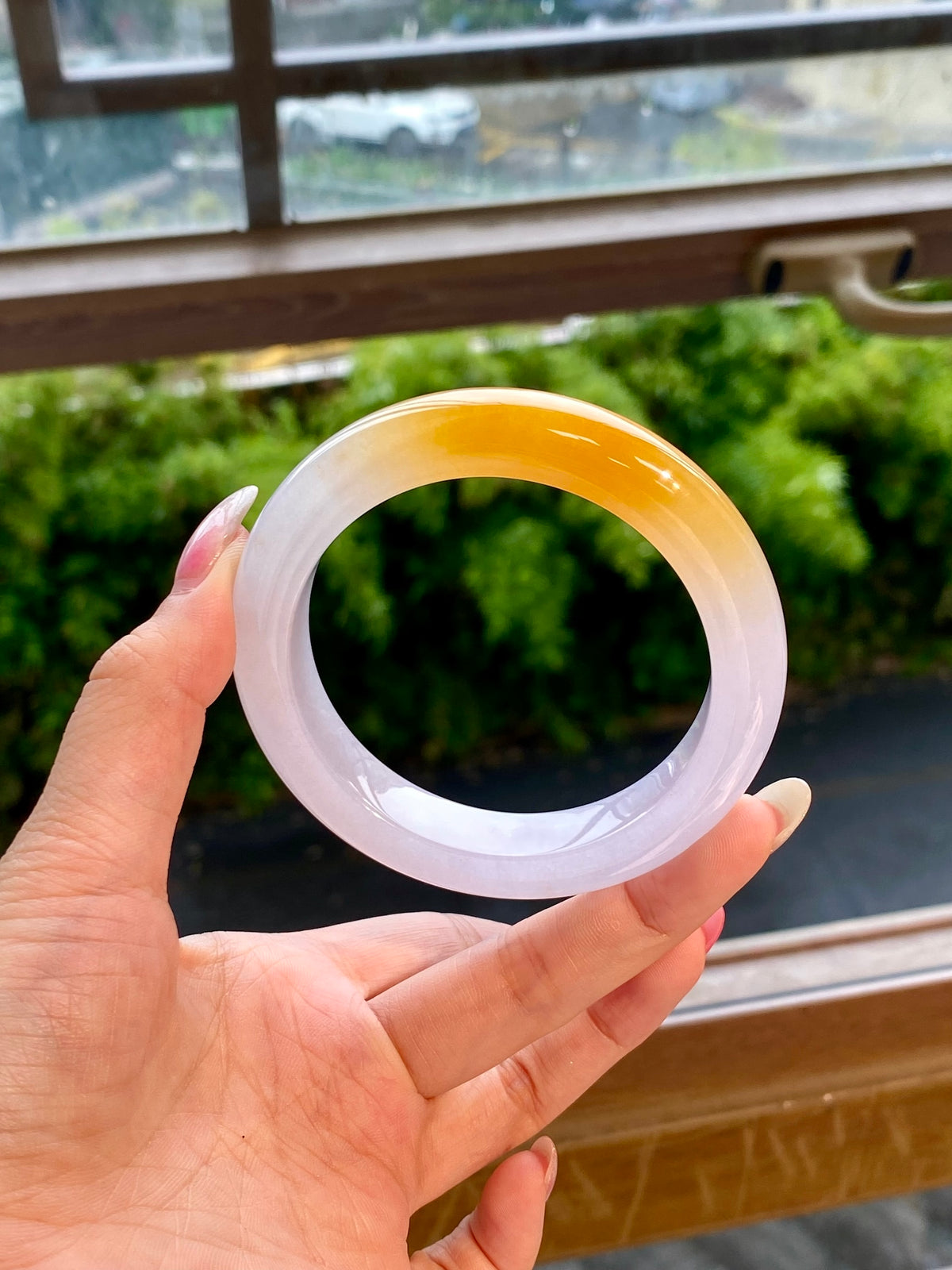 Translucent jadeite bangle with golden-yellow outer ring and pale white inner rim