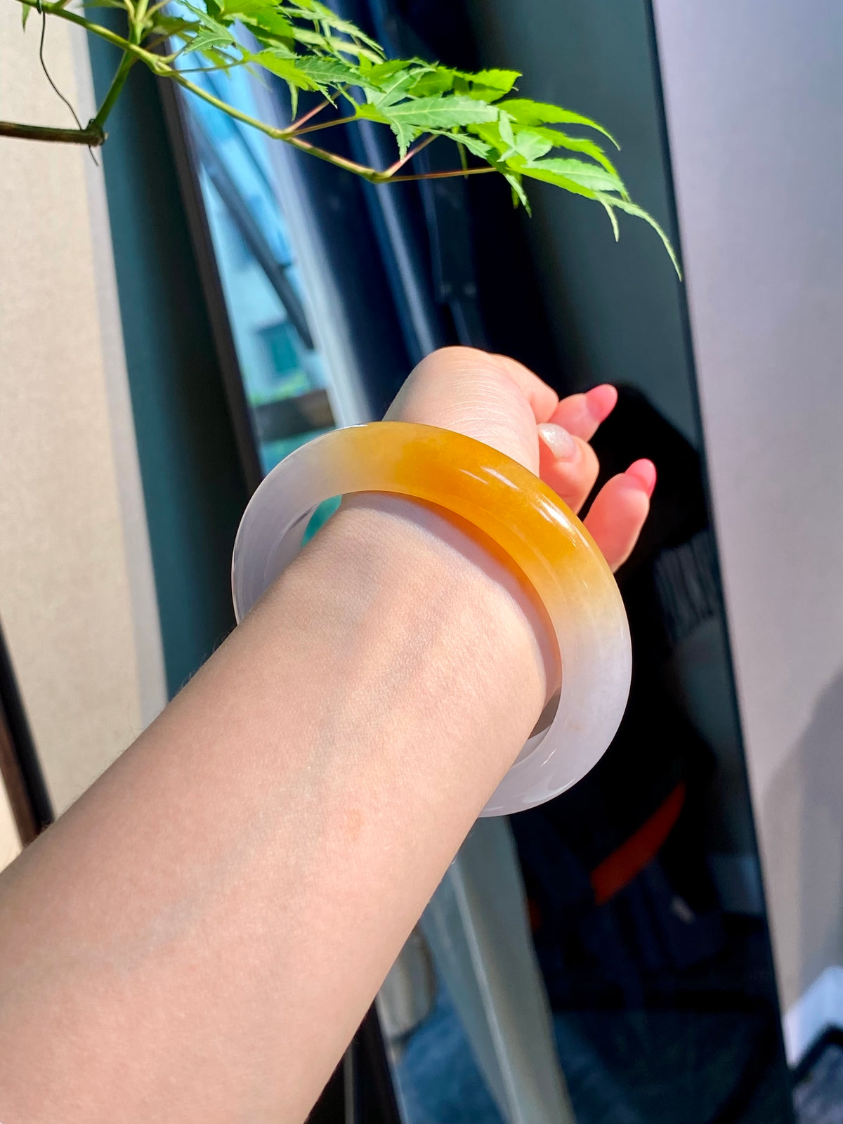Translucent yellow jadeite bangle with pale white inner band, smooth round bracelet