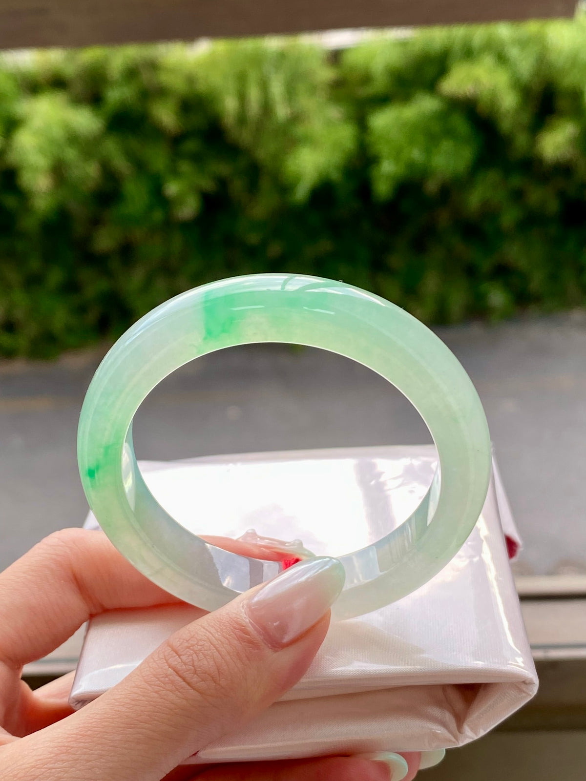 Light green jadeite bangle with glossy finish, close-up of round profile